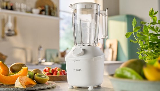 Witte Philips blender op een aanrecht, omringd door fruit.