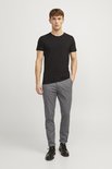 Model draagt een zwarte t-shirt en een grijze broek met fijne structuur.