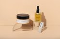 Gouden gelmasker, vitamine C serum en spatel op transparante displays.