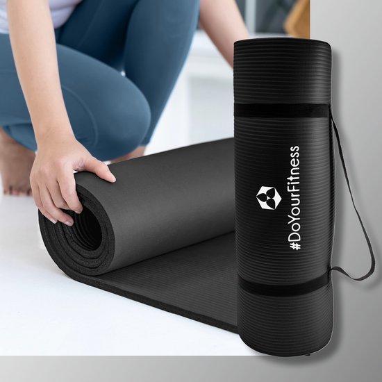 Zwarte fitnessmat met draagtas en tekst #DoYourFitness, terwijl een persoon de mat oprolt.