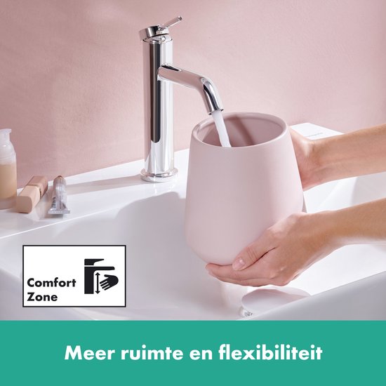 Chromen wastafelkraan boven een roze pot, water stroomt erin. Tekst 'Comfort Zone' en 'Meer ruimte en flexibiliteit'.