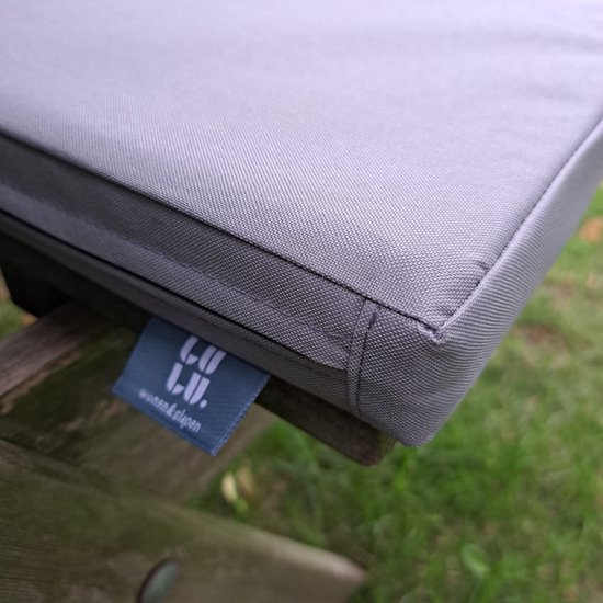 Detail van een grijs kussen met label 'LuLu wonen & slapen'.