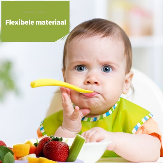Baby met blauwe ogen met een gele lepel in de mond, zittend aan tafel met fruit.