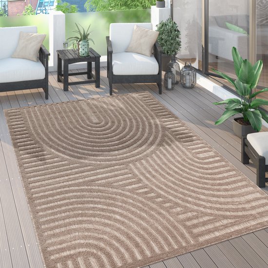 Tapis beige avec motif géométrique abstrait de lignes courbes et de rayures droites, sur une terrasse en bois.