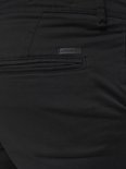 Detail van achterzak met zwart Jack & Jones label op een zwarte chino broek.