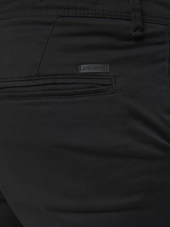 Detail van achterzak met zwart Jack & Jones label op een zwarte chino broek.