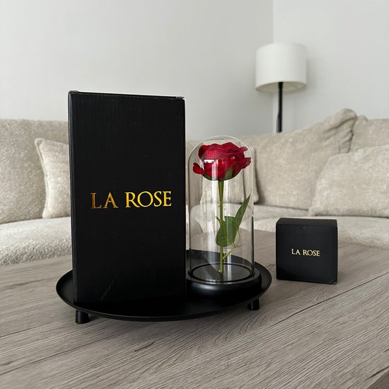 Een rode roos in glazen stolp, met een grote en kleine 'LA ROSE' geschenkdoos op een dienblad.