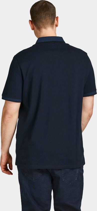 Achterkant van een donkerblauw poloshirt met korte mouwen, gedragen door een man.