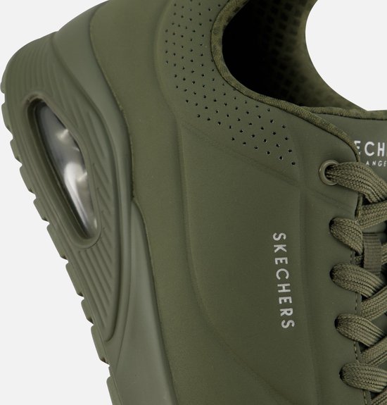 Gros plan d'une sneaker Skechers verte avec lacets, perforations et amorti air.