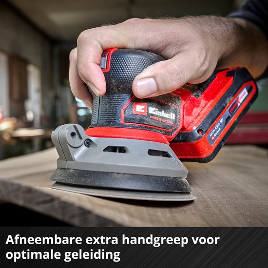Hand van een persoon die een rode en zwarte schuurmachine op een houten oppervlak gebruikt.