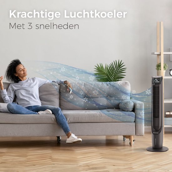 Vrouw op bank genietend van koele lucht van zwarte CoolHome torenventilator, 26°C.
