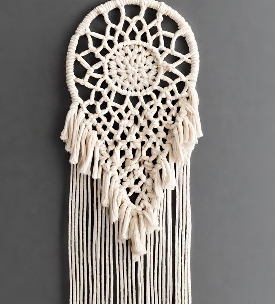Wit macramé wanddecoratie met franjes en een spinnenwebachtig patroon.