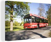 Canvas Schilderij Een zijaanzicht van een rijdende bus - 60x40 cm - Wanddecoratie
