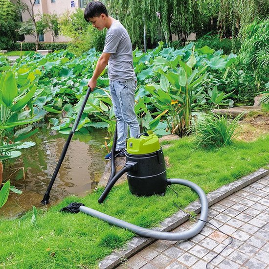 Man stofzuigt een vijver met een zwarte en groene vijverstofzuiger.