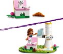 Een LEGO Friends pop laadt een elektrische auto op bij een windmolen met zonnepanelen. Een hondje zit op een roze stoel.