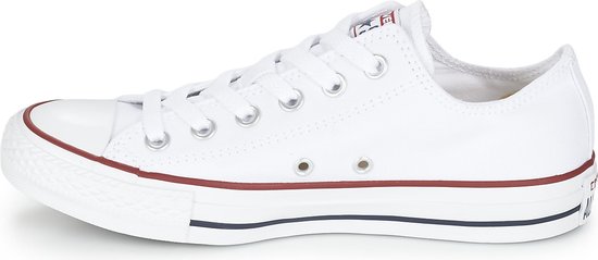 Witte lage Converse sneakers met rode en blauwe accenten op de zool.