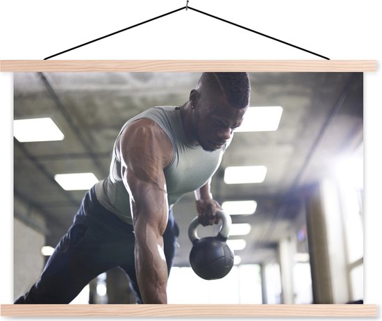 Posterhanger incl. Poster - Schoolplaat - Een sterke man tilt tijdens fitness kettlebells omhoog - 150x100 cm - Blanke latten