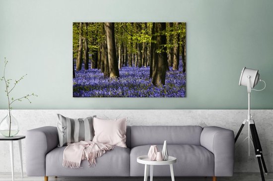 Canvas Schilderij Tussen de bomen liggen paarse bloemen van de sterhyacint - 120x80 cm - Wanddecoratie
