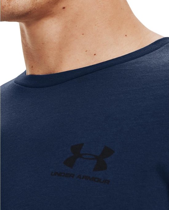 Detail van een donkerblauw sportshirt van Under Armour met zwart logo en merknaam.