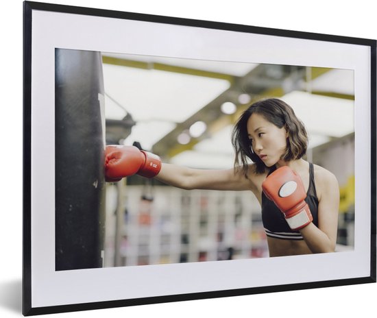 Fotolijst incl. Poster - Een boksende vrouw deelt een klap uit aan de  boksbal - 60x40... | bol.com