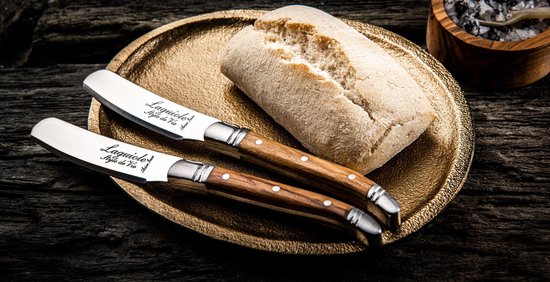 Twee Laguiole botermessen bij brood.