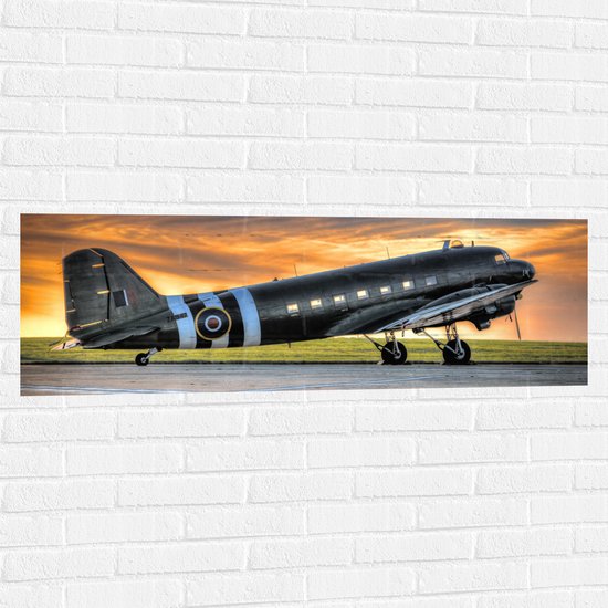 WallClassics - Muursticker - Zwart Vliegtuig bij Zonsondergang - 120x40 cm Foto op Muursticker