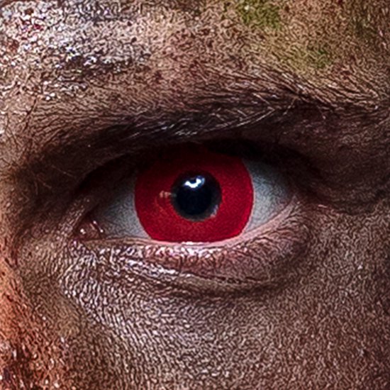 Extreem close-up van een oog met een rode contactlens en zwarte pupil, omringd door vuile huid.