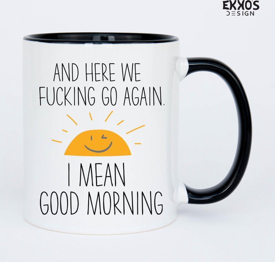 Witte mok met zwarte rand en oor, op een witte achtergrond. Tekst: "AND HERE WE FUCKING GO AGAIN. I MEAN GOOD MORNING" met lachende zon.