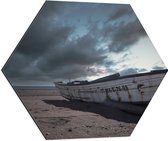 WallClassics - Dibond Hexagon - Witte Boot op het Strand onder Donkere Wolken - 60x52.2 cm Foto op Hexagon (Met Ophangsysteem)