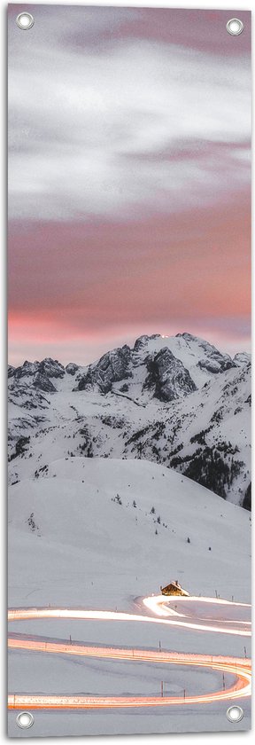 Tuinposter – Verlichte Weg door Sneeuw Landschap en Bergen tegen de Avond - 30x90 cm Foto op Tuinposter (wanddecoratie voor buiten en binnen)