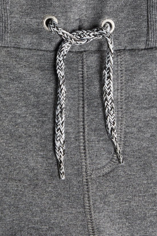 Detail van een grijze joggingbroek met trekkoord met zwart-wit patroon.