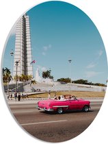 WallClassics - PVC Schuimplaat Ovaal - Roze Auto bij Gebouw in Cuba - 30x40 cm Foto op Ovaal (Met Ophangsysteem)