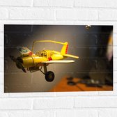 WallClassics - Muursticker - Geel Kinderspeelgoed Vliegtuigje Zwevend in Kinderkamer - 60x40 cm Foto op Muursticker