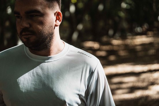 Photo détaillée de l'épaule et du cou d'un homme portant un t-shirt de sport blanc Rogelli.