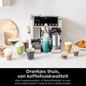 Zilverkleurige Ninja koffiemachine omringd door diverse koffiedranken en croissants.
