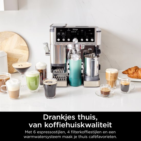 Zilverkleurige Ninja koffiemachine omringd door diverse koffiedranken en croissants.