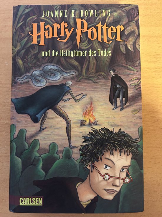 De voorkant van Harry Potter 7 und die Heiligtümer des Todes. Harry Potter, Ron, Hermione en een slang in een bosrijke omgeving met een kampvuur.