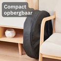 Zwarte, compacte opbergtas voor de vuurschaal, staand naast een stoel.