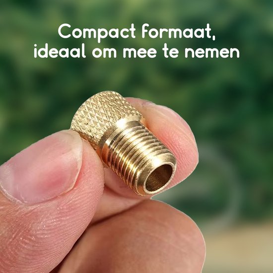 Gouden adapter met schroefdraad, vastgehouden door vingers. Compact formaat, ideaal om mee te nemen.