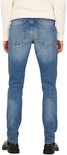 Man met een crème kabeltrui en blauwe jeans, achterkant.