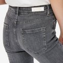Detail van de achterkant van een lichtgrijze denim jeans met merklabel.