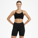 Zwarte sport BH met ruches en korte broek, gedragen door een blonde vrouw met de handen in de zij.