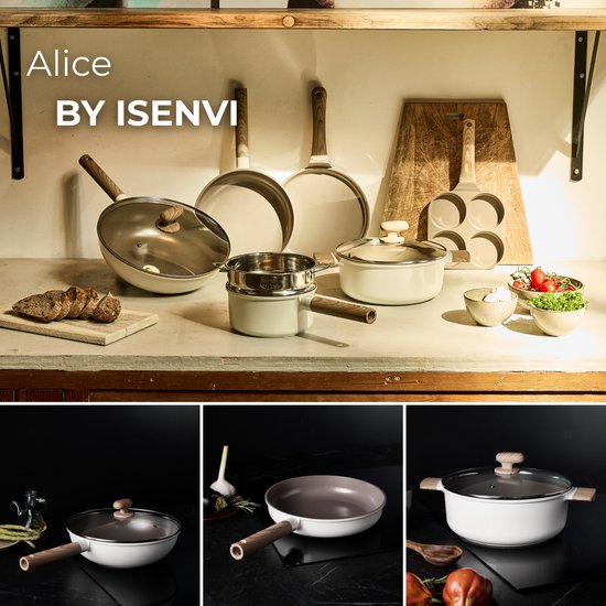 Une collection de casseroles beiges à poignées en bois, comprenant des poêles, des marmites et un wok, avec du pain, des légumes et une cruche en arrière-plan.