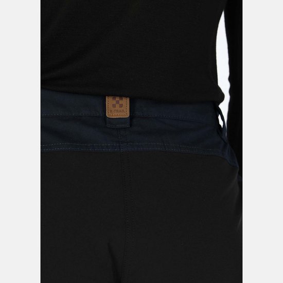 Bruin leren "X-TRAIL" label op de donkerblauwe band van een outdoorbroek.