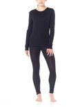 Vrouw in het zwart gekleed in een Icebreaker thermolegging en longsleeve.