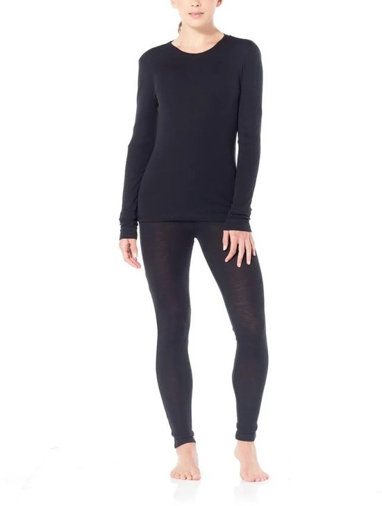 Vrouw in het zwart gekleed in een Icebreaker thermolegging en longsleeve.