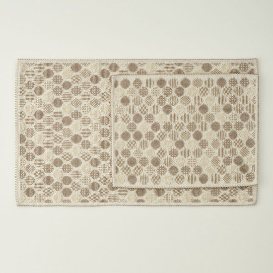 Twee beige en witte kelims met cirkels en ruiten patroon. De grootste is 60x100 cm, de kleinste is 50x60 cm.