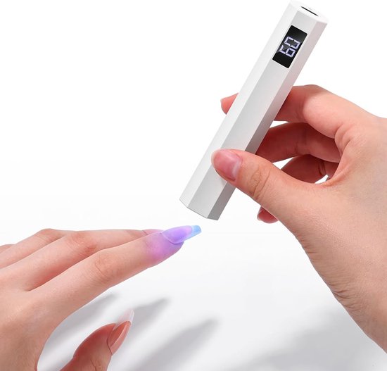 Witte, hexagonale mini nagellamp met display '60' die een vinger onder een paarse UV-lamp houdt.