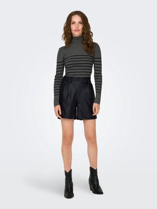 Model in een gestreepte coltrui en zwarte kunstleren shorts met plooien en knopen, gecombineerd met zwarte enkellaarsjes.