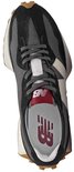 Bovenaanzicht van een zwarte New Balance sneaker met grijs, beige en witte details. New Balance logo op binnenzool.